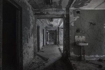 A scary room with a staircase in an abandoned building. Dirty and shabby walls. Stairs with steps. An empty forgotten place. Corridor with a window.