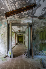 Fototapeta na wymiar A scary room with a staircase in an abandoned building. Dirty and shabby walls. Stairs with steps. An empty forgotten place. Corridor with a window.