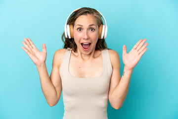 Fototapeta premium Young caucasian woman isolated on blue background surprised and listening music