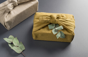 Eco-friendly gifts wrapping in linen cloth. furoshiki gift. Gray background. closeup