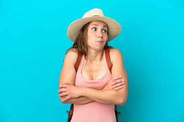 Young caucasian woman in summer holidays isolated on blue background making doubts gesture while lifting the shoulders