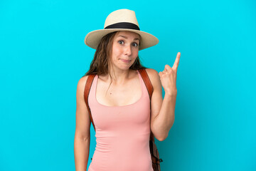 Young caucasian woman in summer holidays isolated on blue background pointing with the index finger a great idea