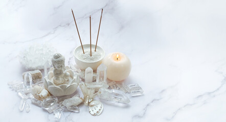 candle, clear quartz minerals, Buddha statue, aroma sticks on abstract marble background. esoteric...