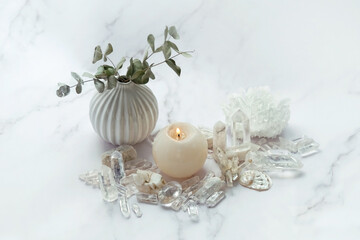 clear minerals and candle on abstract marble background. esoteric spiritual practice for aura...