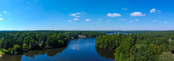 a stunning aerial panoramic shot of the blue waters of Lake Peachtree with vast miles of lush green...