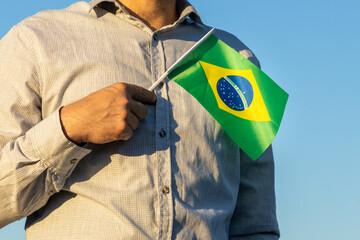 Man holding a brazil flag to his heart with pride