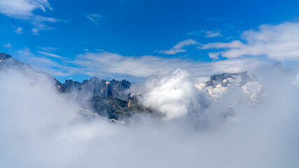 Fototapeta na wymiar Alpine landscape. High mountains in the clouds.