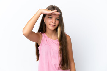Little caucasian girl isolated on white background looking far away with hand to look something