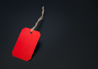 Blank price tags made of red paper or gift tags on a black background. Blank price tag with cord....