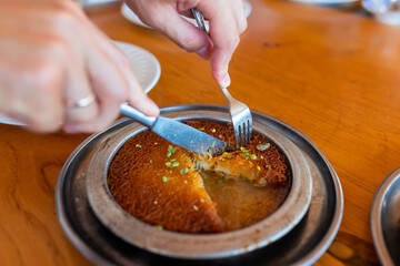 Turkish dessert kunefe, kunafa, kadayif with pistachio powder and cheese, served hot, very sweet.