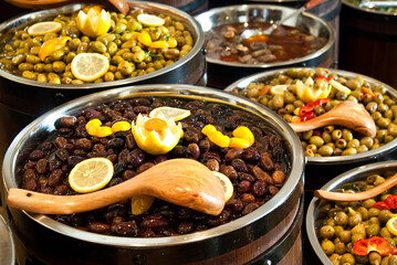 Range of different kinds olives arranged in wooden barrels