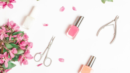 A set of manicure tools and accessories on a white background with flowers. Nail care. Flat lay. Copy space. Women's Day. March 8