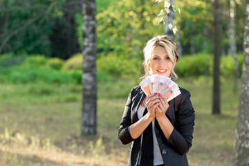 young woman holding a lot of money in her hands. Good mood, wealth concept