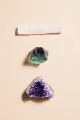 druse raw purple amethyst crystal, selenite and fluorite on beige background, magic rock for...