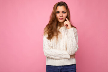 Portrait of young attractive caucasian hipster woman in trendy casual clothes. Sexy carefree female person posing isolated near pink wall in studio. Positive self-confident serious model with natural