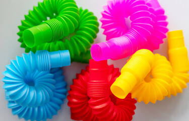 colorful antistress sensory toy fidget push pop tube in on blue background