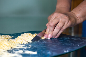a woman cuts homemade noodles in the kitchen
