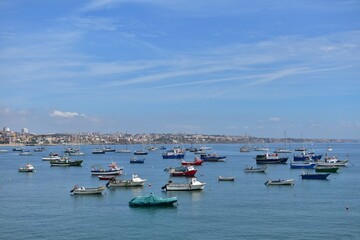 Fototapeta na wymiar Boats in the harbor. Motor fishing boats in the bay on background of blue sky and sea town in haze