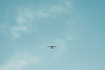 Silhouette of small plane flying in clear sky. Isolated airplane in the skies.