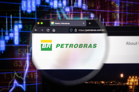Petrobras company logo on a website with blurry stock market developments in the background, seen on a computer screen through a magnifying glass