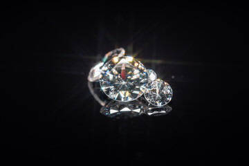 Diamonds selective focus on black reflective background. Polished gem stones of different size...
