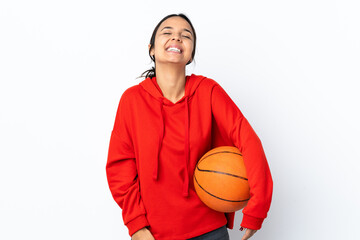 Young woman playing basketball over isolated white background laughing