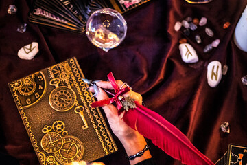 mysterious witch writing in a steampunk book with red feather for halloween