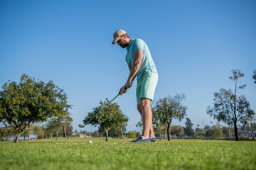 active golfer in cap with golf club, golfing