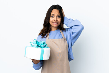 Pastry chef holding a big cake over isolated white background doing nervous gesture