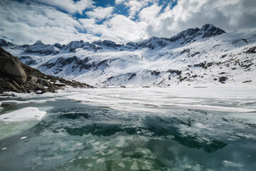 Fototapeta na wymiar Broken Ice in the Waters of Dosazzo Lake during Spring, Adamello park, Lombardia, Italy