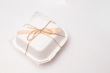 Packed bento cake in white eco-friendly packaging, tied with jute. White background with space for text. Selective focus.