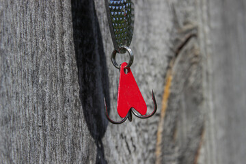 Fishing lure for catching predatory fish on a wooden background close-up view from above. White...