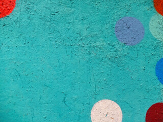 Turquoise painted wall with white, red, blue semicircles and blue circle as background or texture