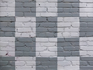Brick wall painted in gray and white in checkerboard pattern as background or texture