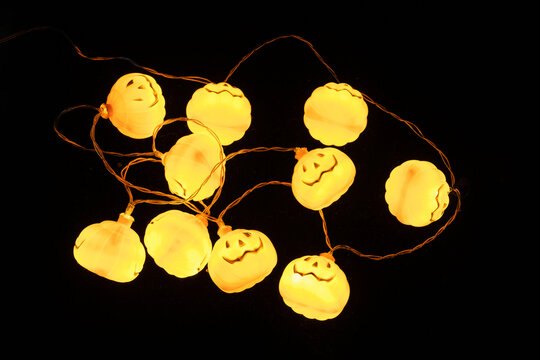 Glowing Orange Garland With Halloween Pumpkin Lamps On Black Background