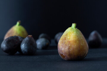 Big and small fresh figs jn black background
