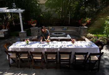Woman setting up dinner table outdoor 