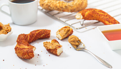 Turkish bagel breakfast concept with coffee, honey and peanut butter. Isolated image over white.