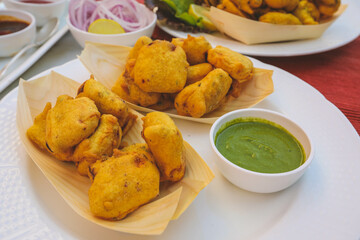 Batata vada or aalu bonda or aalu bonde, a tasty indian snacks, served with tomato ketchup or green chilli and onion