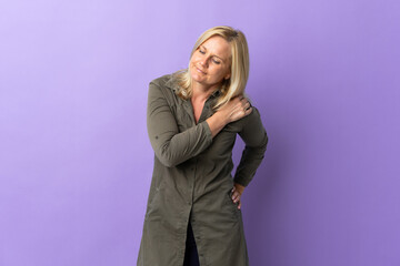 Middle age Lithuanian woman isolated on purple background suffering from pain in shoulder for having made an effort