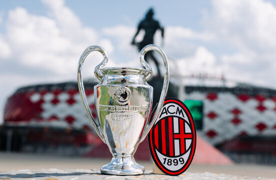 June 14, 2021 Milan, Italy. A.C. Football Club emblem Milan and the UEFA Champions League Cup against the backdrop of a modern stadium.