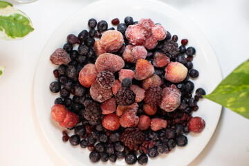 Frutos rojos congelados en plato con vista cenital