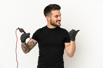 Tattoo artist man over isolated white background pointing to the side to present a product