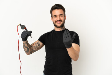 Tattoo artist man over isolated white background inviting to come with hand. Happy that you came