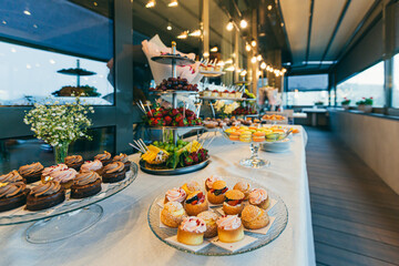 Festive buffet table with delicious desserts of different colors at the wedding ceremony