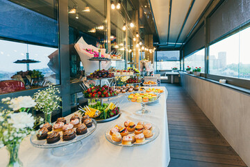 Festive buffet table with delicious desserts of different colors at the wedding ceremony