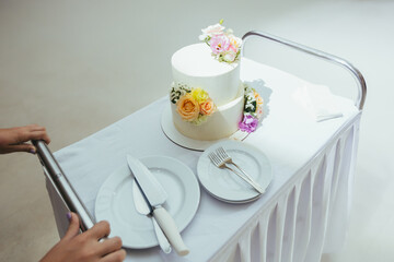Wedding cake in a white restaurant decorated with fresh flowers