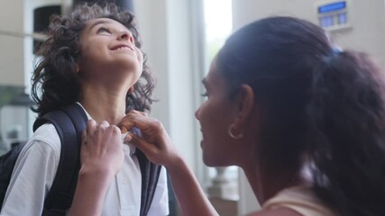 Slow motion of mother helping son get ready for school