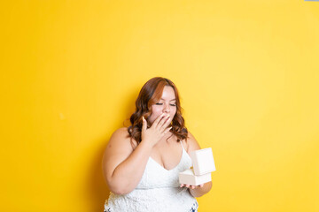 fat young model opening gift box with surprise face at christmas