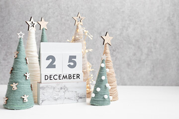 Christmas craft background with calendar and handmade yarn cone xmas trees in natural colors. DIY organic sustainable christmas decoration
